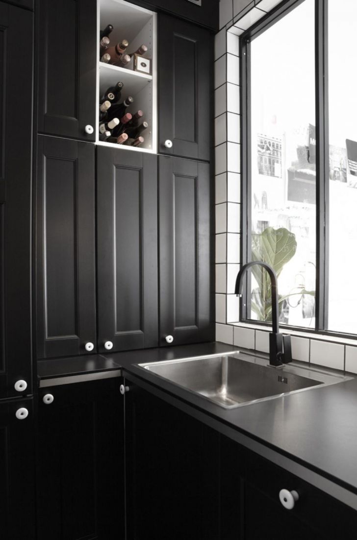Темная кухонная мебель квартиры с темным дизайном